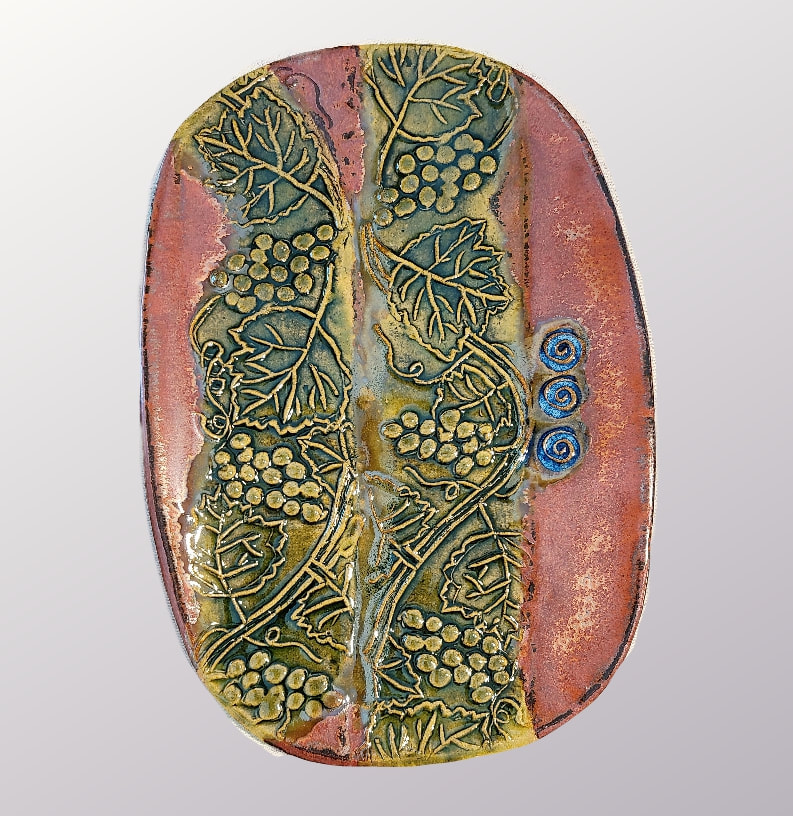 Grape & Leaf pattern platter - Ceramics: Clay has called to Linda Levy  - LA Levy - Linda A. Levy - for over 50 years.  She has learned wheel throwing techniques, handbuilding, as well as glaze chemistry.  Her latest sculptural works are inspired by working with live models.  Linda's handbuilt plates and platters usually use her hand-created ceramic rollers to impart designs & textures.